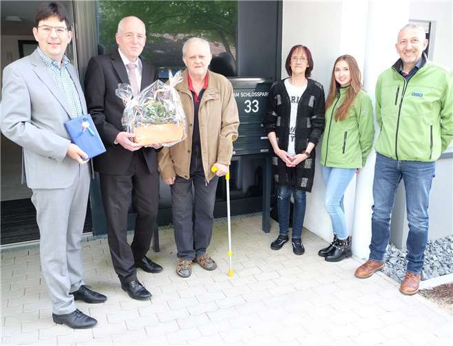 Bürgermeister Michael Mang (li.) und GSG-Geschäftsführer Carsten Boberg (zweiter v.li.) überreichten Hans-Joachim Zober kurz vor dem Einzug zwei Geschenke. Mit ihnen freuen sich Heike Werner (dritte v.re.), die die Zobers im Alltag bei Einkäufen und Arztgängen unterstützt, sowie Elena Daniel und Manfred Schlug von der GSG. Foto: privat