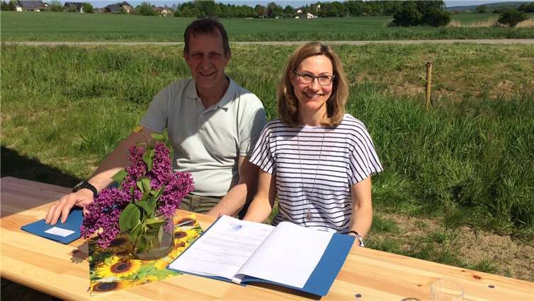 Bürgermeister Mumm und Lydia Brück unterzeichnen den Bachpatenschaftsvertrag.