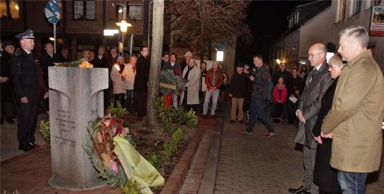 Bürgermeister Spilles und seine Vertreter, Heidi Wiens und Michael Sperling (v.l.), legen einen Kranz nieder am Denkmal auf dem Synagogenplatz.Stein