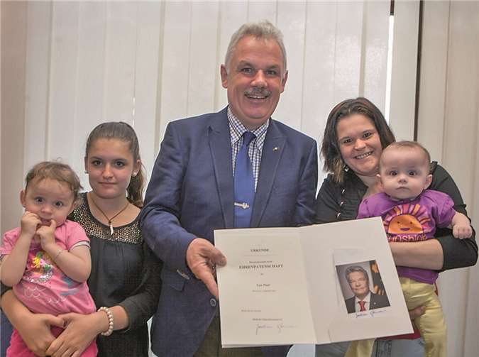 Bürgermeister Stefan Raetz überreichte die Urkunde über die Ehrenpatenschaft von Bundespräsident Joachim Gauck für die kleine Lea Paul (rechts) an ihre Mutter Sabrina Bartke. Die beiden Schwestern Leonie und Zoé (links) freuen sich ebenfalls. VJ