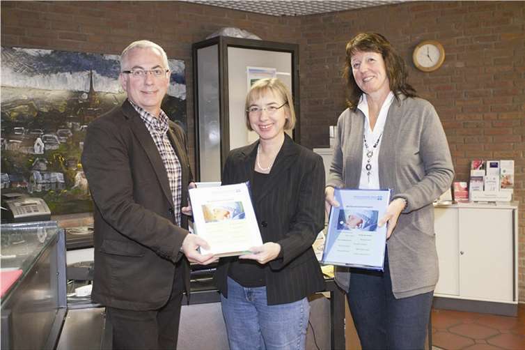 Bürgermeister Volker Mendel, Pfarrerin Renate Schäning und Beraterin Elke Voß vom Diakonischen Werk halten die ersten Elternordner für Väter und Mütter bereit. privat