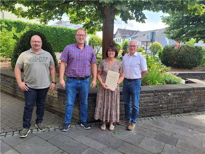 Bürgermeister Volker Mendel ehrte die Mitarbeiterin mit einer Dankurkunde und überreichte ihr den Wappenteller der Verbandsgemeinde Puderbach. Quelle: VG Puderbach