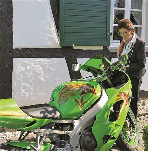 Bürgermeisterin Renate Offergeld betrachtet die Airbrush-Malereien auf dem Motorrad. Gemeinde Wachtberg/mm
