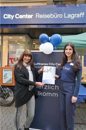 Büroleiterin Bianca Rascher überreicht Ute O. den Hauptgewinn, einen TUI Reisegutschein in Höhe von 500,00 Euro.