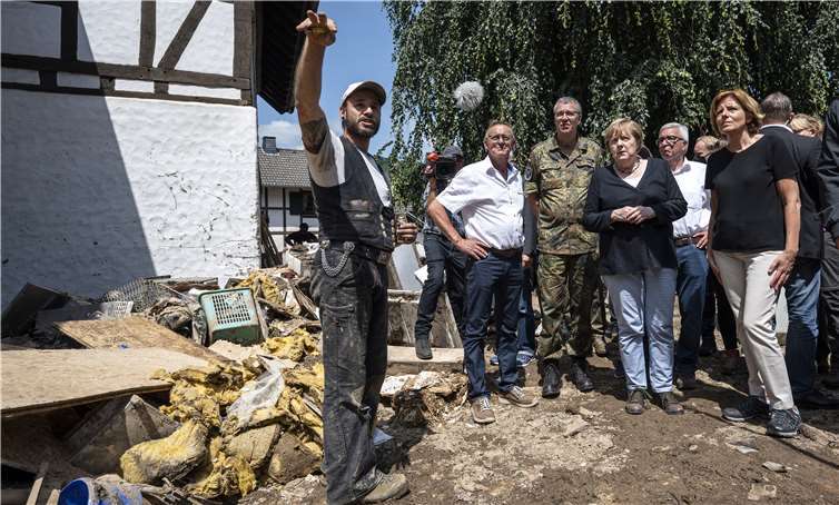 Bundeskanzlerin Angela Merkel (hinten 3.v.l.) im Gespräch mit Betroffenen bei einem Rundgang durch den vom Hochwasser zerstörten Ortskern (hinten l. Helmut Lussi, Bürgermeister Schuld; r. Malu Dreyer, Ministerpräsidentin von Rheinland-Pfalz; hinten 2.v.r. Roger Lewentz, Innenminister von Rheinland-Pfalz).Foto: Bundesregierung / Guido Bergmann