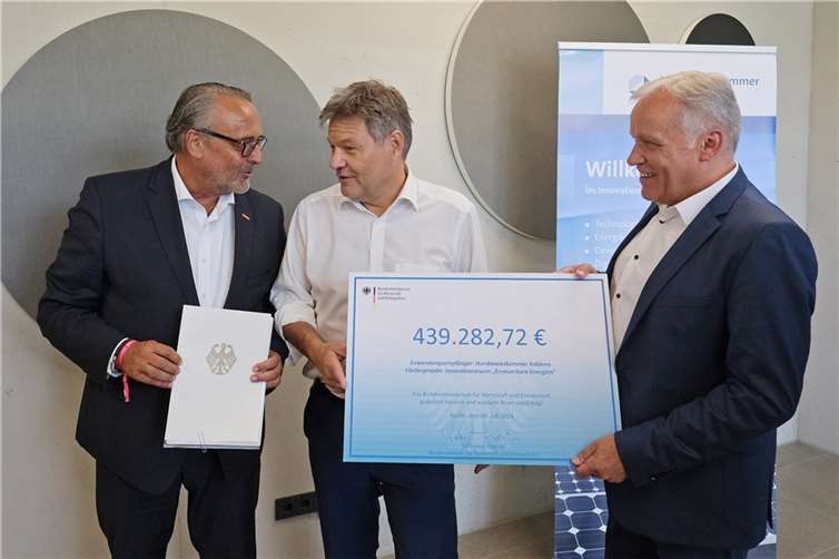 Bundeswirtschaftsminister Robert Habeck (Mitte) überreicht Ralf Hellrich (links) und Kurt Krautscheid einen Förderbescheid in Höhe von rund 440.000 Euro für die Stärkung der beruflichen Bildung (im Rahmen des Förderprojekts Innovationsraum „Erneuerbare Energien“.