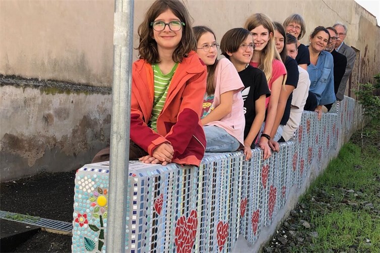 Buntes Treiben am PikoPark: Mit einigen der teilnehmenden Kinder feierten auch (von hinten) der Sinziger Beigeordnete Volker Thormann, der Leiter des Sinziger Werks der Deutschen Steinzeug Solarceramics GmbH, Michael Podewils, Projektbetreuerin Barbara Henschke und die Vorsitzende des Bürgerforums, Monika Weber-Lambert, die offizielle Übergabe des Mosaikprojekts.