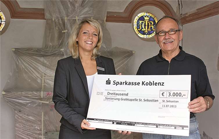 Caroline Domenichini, Leiterin der Sparkasse in Urmitz, überreicht den symbolischen Scheck an den Vorsitzenden des Fördervereins, Hajo Reif. privat