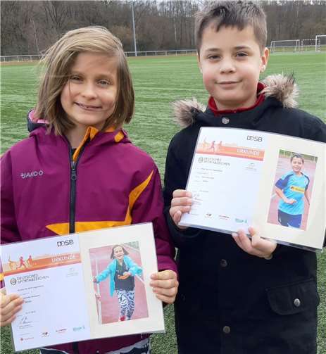 Charlotte und Henri Ahlswede (LT Puderbach) mit den Sportabzeichen Urkunden des DOSB (Deutscher Olympischer Sportbund). Stolz halten beide ihre Urkunde in die Kamera. Foto: Dietrich Rockenfeller - Lauftreff Puderbach