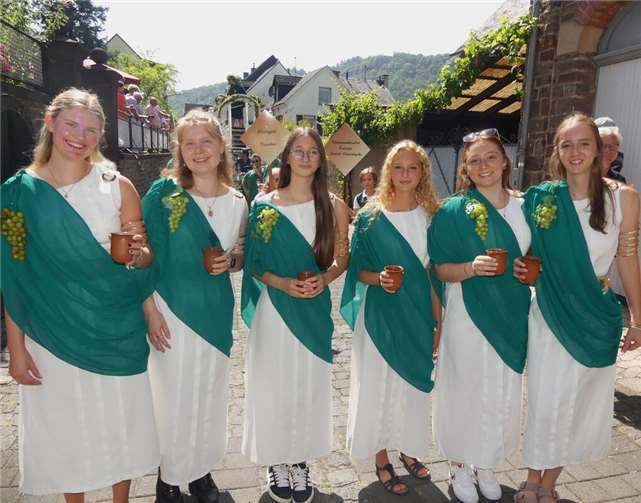 Charmante junge Weinrömerinnen prosteten den fröhlich feiernden Weinfreunden während des Umzuges freundlich zu.