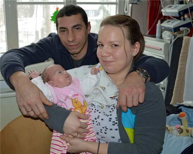 Chayenne im Arm von Mutter und Vater.