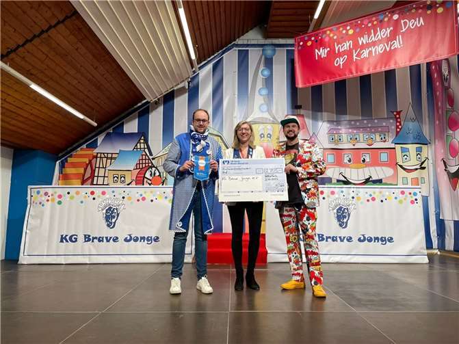 Checkübergabe der VR-Bank an die KG Brave Jonge vor der Kulisse der neuen Deloration, v.l. Pierre Fischer (1. Kassierer KG Brave Jonge), Juliane Rams (1. Vorsitzende KG Brave Jonge) und Sebastian Jacke (VR-Bank). Quelle: KG Brave Jonge 