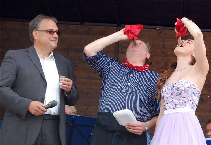 Cheforganisator Werner Pommer und Brunnenkönigin Laura zeigen, wie man Matjes zünftig schluckt. Bernd Weidenbach kann an dem Vergnügen nicht teilhaben - er tröstet sich mit einem Schluck Genever. FA