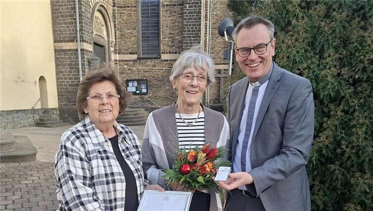 Chorvorsitzende Monika Leinz, Ehrenvorsitzende Karola Breitbach und Präses Pfarrer Norbert Missong vor der Sankt Arnulf Pfarrkriche. Foto: Norbert Bermel