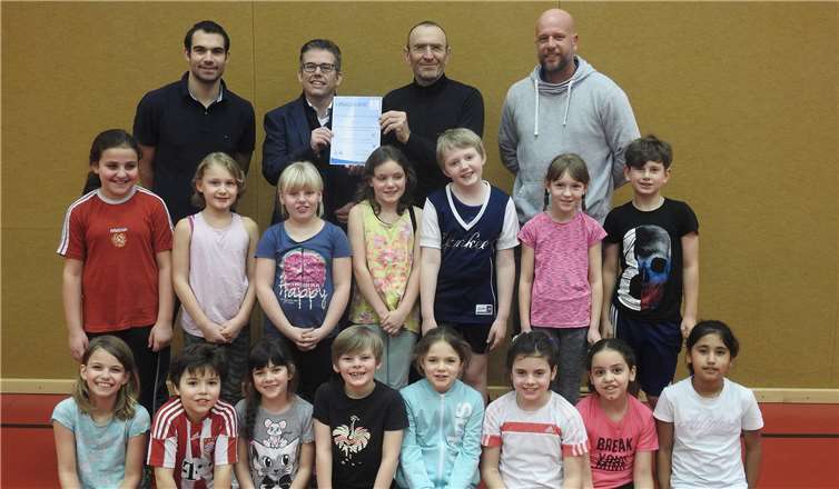 Christian Heller bei der Übergabe der Urkunde an Matthias Jaklen. Rechts Daniel Busch, Konrektor, links Florian Stein, Lehrer, mit Schülern der Grundschule Pfarrer-Bechtel. privat