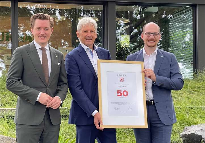 Christian Huf (l.) und Benedikt Huf (r.) erhielten die Jubiläumsurkunde von BDF-Präsident Hans Volker Noller (m.). Foto: HUF HAUS