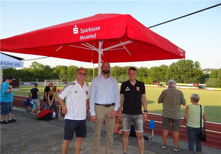 Christian Mirbach (Sparkasse) bei der Übergabe des Sonnenschirmes mit Sparkassen-Logo. privat