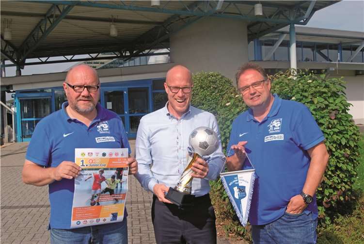 Christian Schröder, EVM Bereichsleiter für Marketing / Kommunikation (Bildmitte) überreichte vor der Philipp-Heift-Halle den neuen Wanderpokal an die Vertreter der SG 2000, Peter Dewald, (Vorsitzender des Fördervereins der Jugendabteilung, links im Bild) und Konny Urmetzer (Jugendleiter, rechts im Bild). Privat