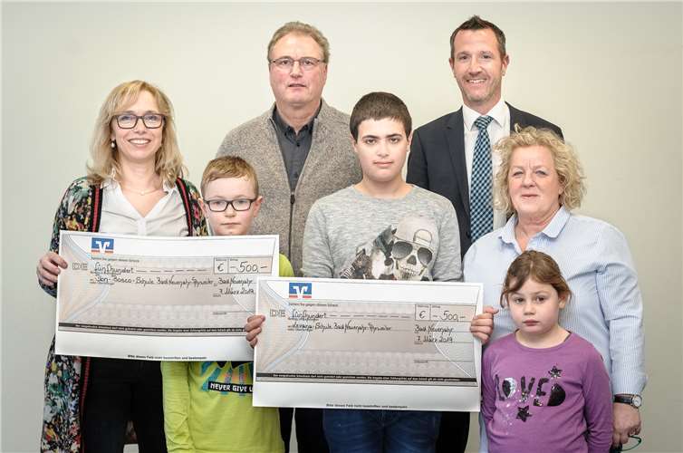 Christian van de Loo (2.v.re.) übergab, im Beisein einiger Schüler, einen Scheck an Annette Masanneck (v.li.n.re.), Jakob Armbrust und Sophia Garcia. Foto: Ingo Goerres