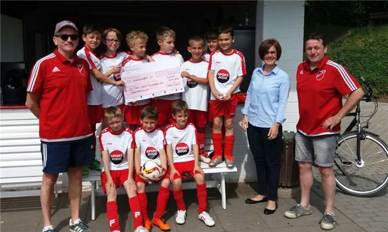 Christina Bartsch, Filialleiterin der Kreissparkasse in Heimerzheim, überreichte vor einem Spiel der F-Junioren einen Scheck über 500 Euro. Der Betrag wird für neue Materialschränke im Verkaufsraum auf dem Sportplatz in Dünstekoven verwendet.privat