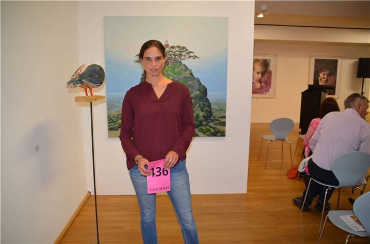 Christina Steinhausen mit ihrer Auktionskarte vor zwei unstwerken.Foto: FDP-AW