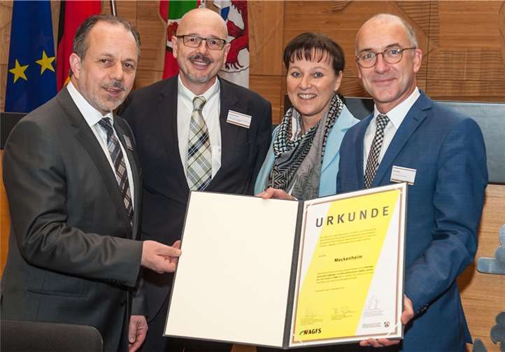 Christine Fuchs, Vorstand der AGFS, und Winfried Pudenz (2. von links), Abteilungsleiter MBWSV, überreichen die Verlängerungsurkunde für die Stadt Meckenheim an Bürgermeister Bert Spilles (rechts) und den Technischen Beigeordneten, Heinz-Peter Witt (links). AGFS/Uwe Reinert