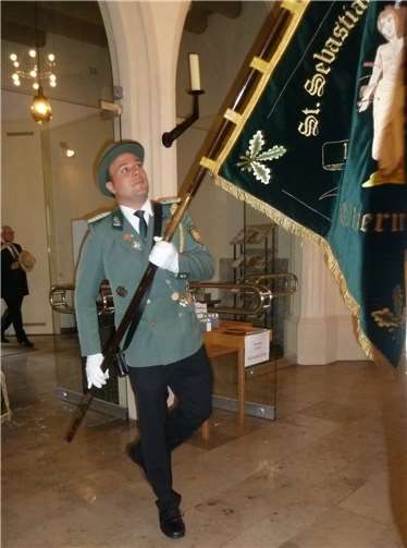 Christoph Nolden trägt die Vereinsfahne beim Gottesdienst.