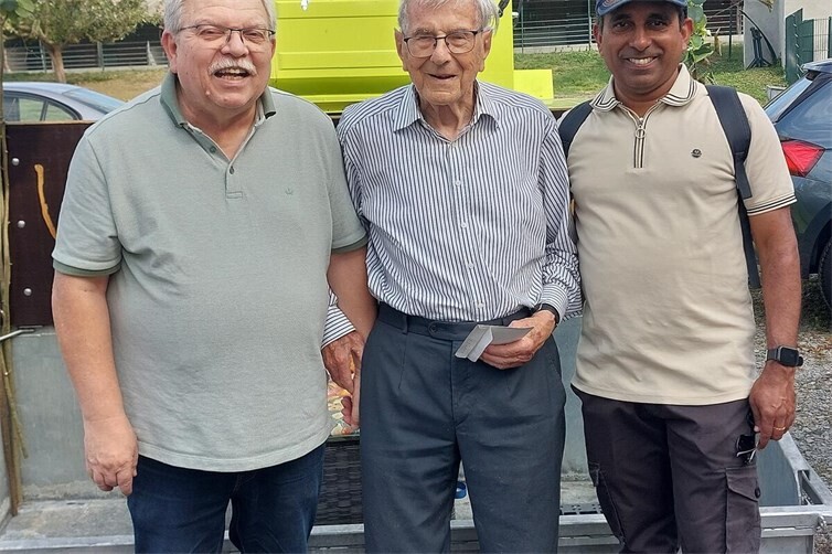 Chronist Detlef Hoell (li). und Wanderfreund Pater Sabi (re.) umringen Alfred Weigt.