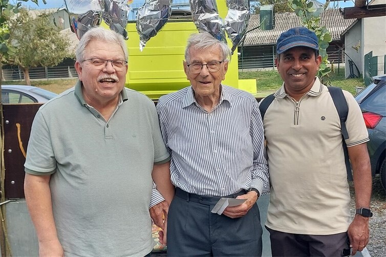 Chronist Detlef Hoell (li). und Wanderfreund Pater Sabi (re.) umringen Alfred Weigt.