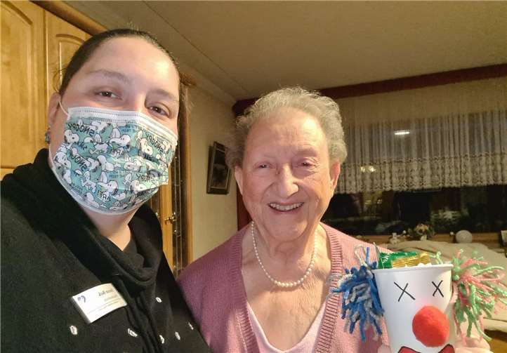 CuraSanus Pflegedienstleitung Doreen Beck ist mit einer karnevalistischen Botschaft unterwegs: gut gefüllte und selbstgebastelte Clownbecher; sehr zur Freude von Amalie Groß aus Bad Neuenahr-Ahrweiler. Foto: privat