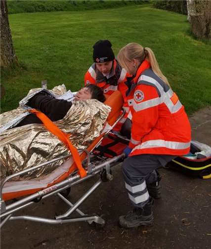 DRK-Einsatzkräfte beim Abtransport einer verletzten Person.