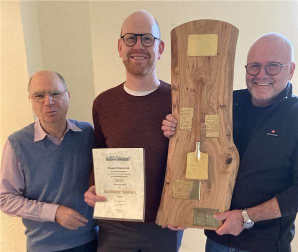 Daniel Harprath nimmt den Goldenen Spaten des Obst- und Gartenbauvereins (OGV) Rheinbreitbach aus den Händen des Vorsitzenden Norbert Buchbender (rechts) und dessen Stellvertreters Josef Weich entgegen.Foto: Heinz Schmitz