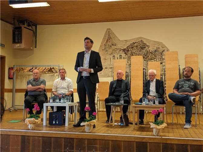Daniel Robbel (stehend) leitete durch die Diskussion, von links, sitzend: Michael Schneider (CDU), Christoph Schmitt (SPD), Ulrich van Bebber (FDP), Jochen Seifert (FWG), Christoph Scheuer (Grüne). Foto: ks