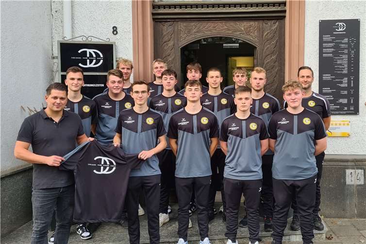 Daniel Röber (vorne li.) übergibt die Shirts an GSG-Mannschaftkapitän Moritz Radermacher (vorne 2.v.l.). Quelle:GSG