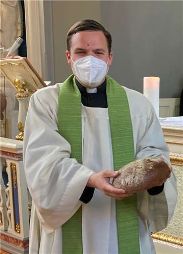 Daniel Sluminsky, neuer Schulseelsorger am St. Joseph-Gymnasium, freut sich über Brot und Salz zum „Einzug“ in sein neues Amt und damit in die Schule.