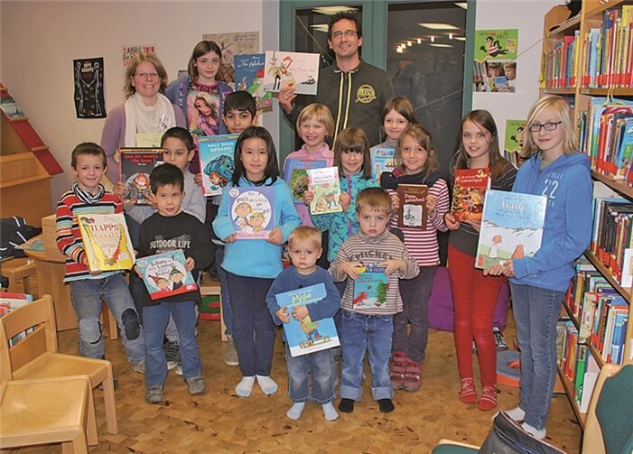 Daniela Hahn, Leiterin der Öffentlichen Bücherei St. Martin, erhielt von Gerd Engel, 2. Vorsitzender Rheinbach liest e.V., im Beisein von den Kindern des Leseclubs, 20 aktuelle Kinderbücher aus der Aktion.  privat