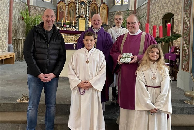 Dankbar nahm der neue Diakon Gaub das Geschenk entgegen. V.li. Dirk Lescher, Messdiener Jonathan, Pfarrer Michael Wilhelm, Messdienerin Lynn, Diakon Heiko Gaub und Messdienerin Emilia. Foto: Martina Schmitt