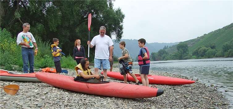 Das Anlegen von Spritzdecken und Schwimmwesten übten Sportwart Hardy Türpe (mit Paddel) und Judith Haag (3.v.li.) mit allen Teilnehmern. privat