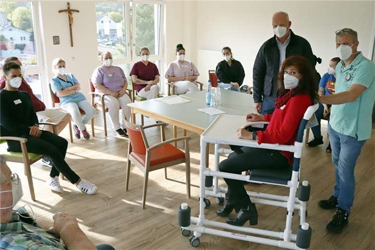 Das Bild zeigt Eindrücke von der Einweisung. Zum Zubehör des Gehwagens gehört unter anderem auch ein Therapietisch.