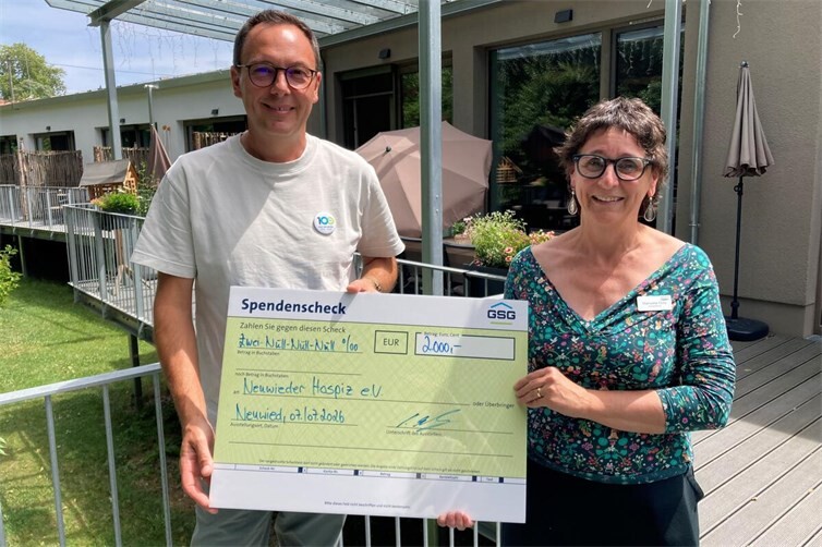 Das Bild zeigt GSG-Geschäftsführer David Meurer und Manuela Götz, Leiterin des Rhein-Wied Hospiz, mit Spendenscheck vor dem ansprechenden Gebäude der Einrichtung in der Aubachstraße. 