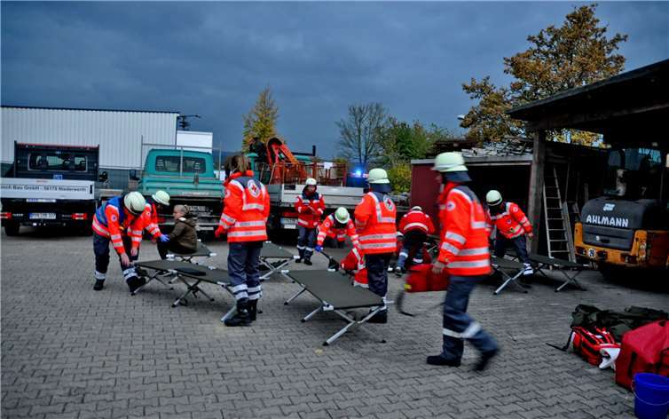 Das DRK baut Feldbetten auf.