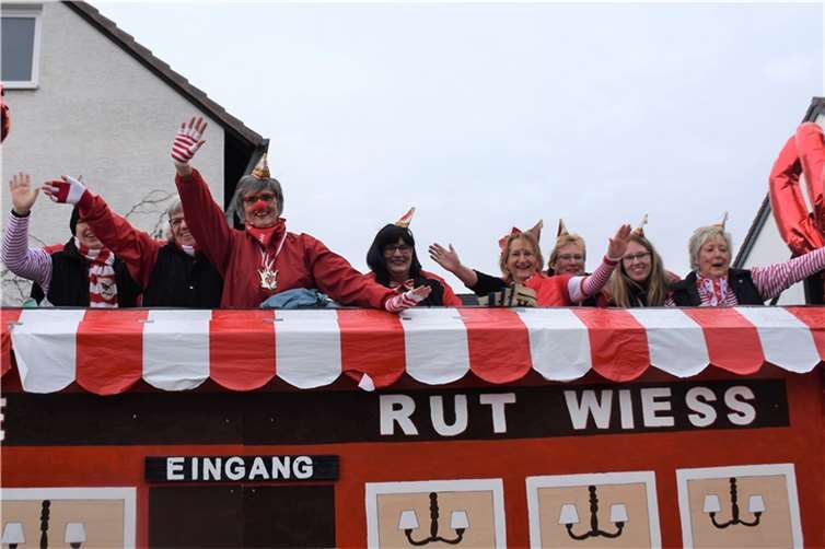 Das Damenkomitee jubelt von ihrem Wagen.