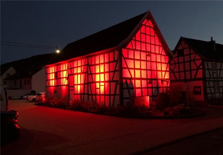 Das Dorfmuseum und die Kulturwerkstatt wurden eindrucksvoll in rotem Licht erhellt. Quelle: Ortsgemeinde Niederbreitbach