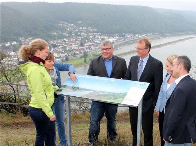 Das Foto zeigt Dr. Friedericke Weber (Naturpark Rhein-Westerwald e. V.), Svenja Keller (Tourismusförderung Verbandsgemeinde Bad Hönningen), Bürgermeister der Verbandsgemeinde Bad Hönningen Michael Mahlert, Landrat Rainer Kaul sowie Ellen Demuth (MdL) und Ortsbürgermeister Oliver Labonde (Rheinbrohl) vor der Panoramatafel an der Rheinbrohler Ley. Tourist-Information Bad Hönningen