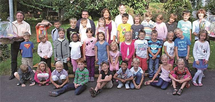 Das Foto zeigt die frisch gebackenen Grundschüler, flankiert von Andrea Knops (Lehrerin Klasse 1a, r.) und Michael Stein (Lehrer Klasse 1b, l.).W. Seidenfuß