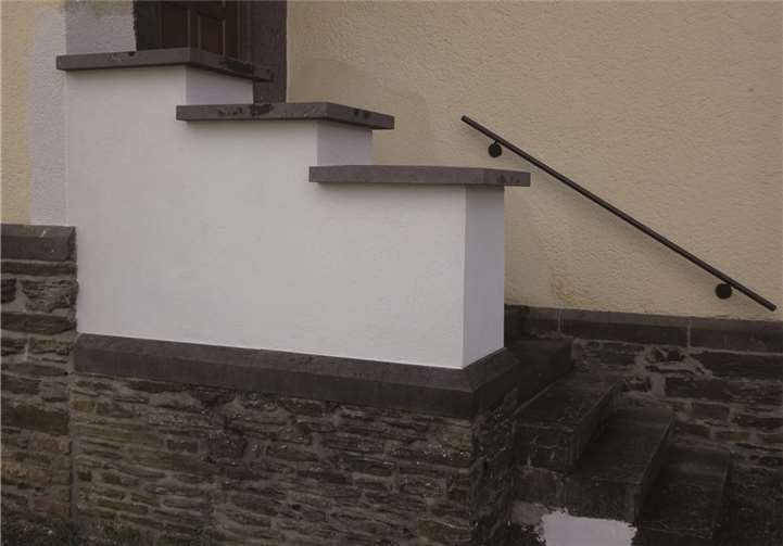 Das Foto zeigt die neu verputzte Flügelmauer mit neuen, größeren Basaltabdeckungen.privat