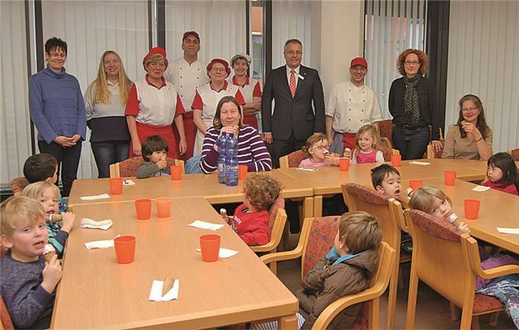 Das Foto zeigt eine Kleinkindergruppe nach einem Mittagessen mit ihren Betreuerinnen, dahinter das Küchenteam der Sparkasse mit Leiter Marcus Fell (vierter von links). Dritter von rechts ist Personalchef Jörg Perscheid, ganz rechts Kita-Leiterin Beate Gabriele Buchberger. privat