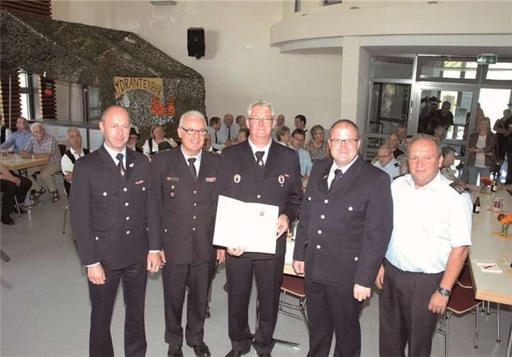 Das Goldene Feuerwehr-Ehrenabzeichen am Band für Norbert Weber; v.l. Wehrleiter Dieter Merten, Kreisfeuerwehrinspekteur Udo Schumacher, Wehrführer Norbert Weber, Bürgermeister der Verbandsgemeinde Adenau Guido Nisius, Vorsitzender Kreisfeuerwehrverband Rolf Genn.