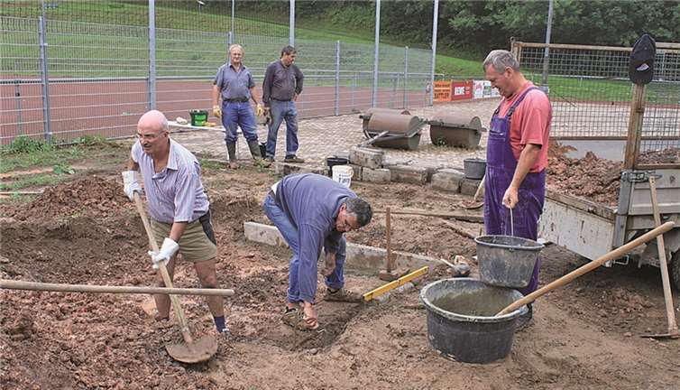 Das Helferteam kämpft sich am Spielplatz durch den Schlamm und baut den neuen Sandkasten.privat