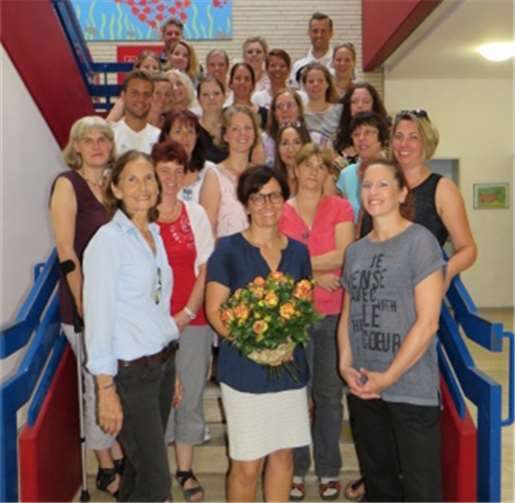 Das Kollegium begrüßt Frau Neukirchen mit einem Blumenstrauß. privat